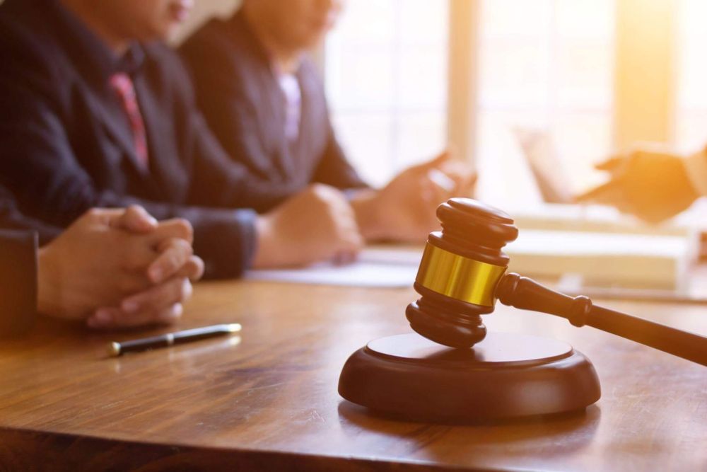 a judge's gavel on a wooden table in a courtroom