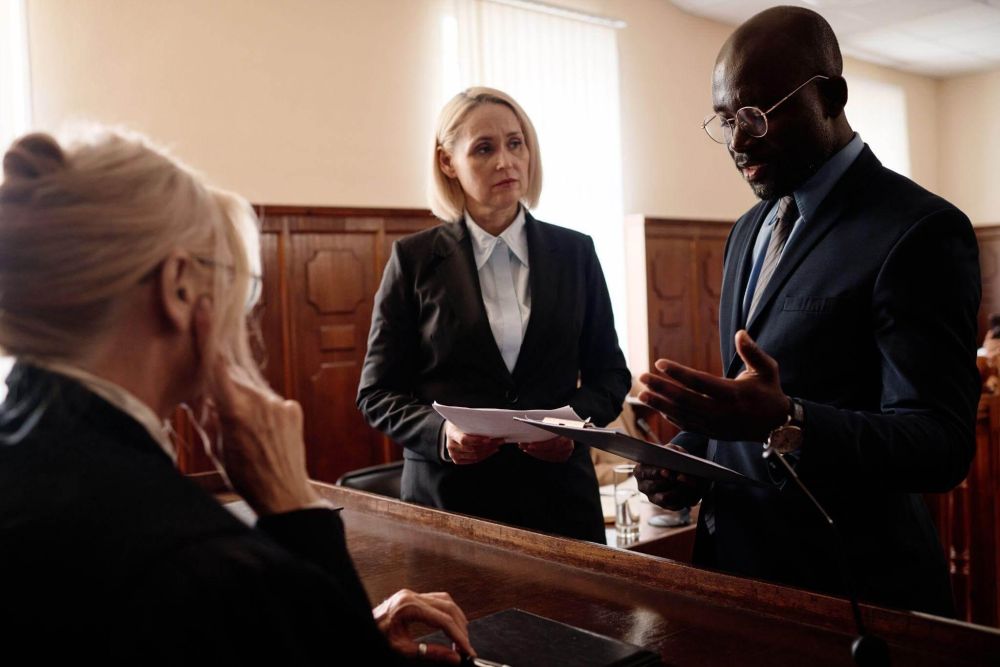 a group of people standing around each other in a courtroom