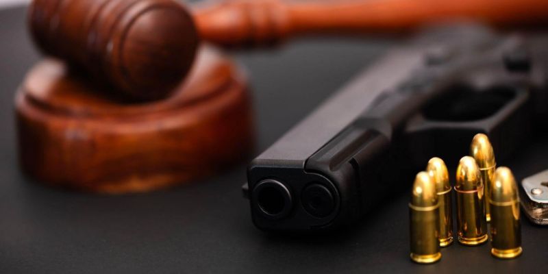 Wooden judge's gavel and gun representing