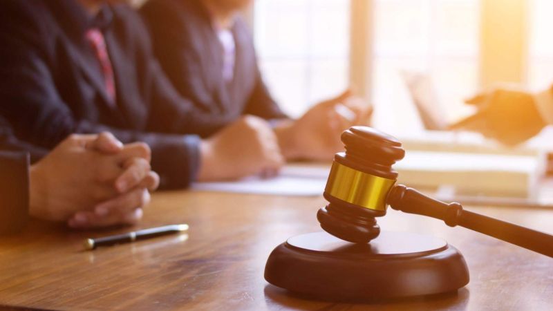 a judge's gavel on a wooden table in a courtroom