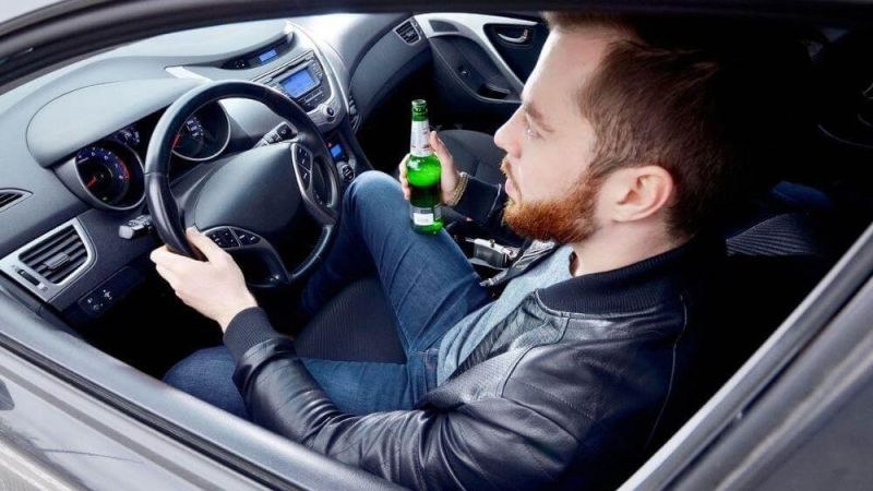 Man driving with beer, illustrating impaired driving in Virginia