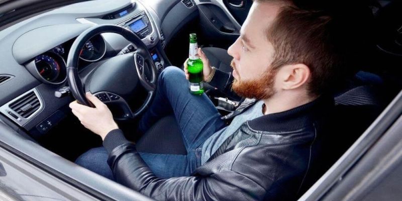Man driving with beer, illustrating impaired driving in Virginia