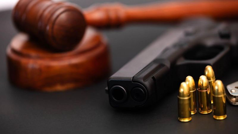 Wooden judge's gavel and gun representing