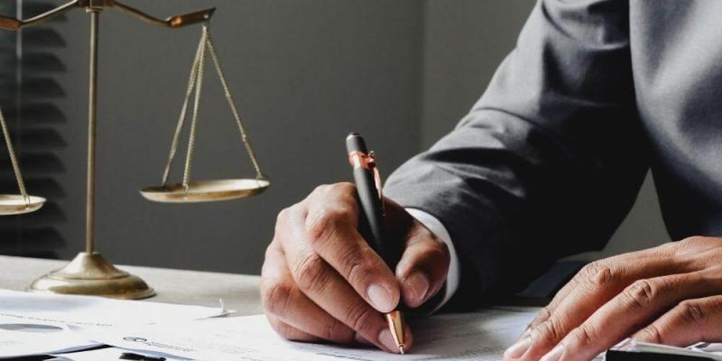 Man in a suit writing legal notes next to