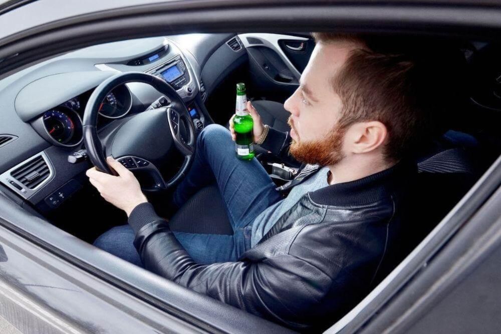 Man driving with beer, illustrating impaired driving in Virginia