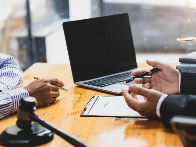 two people sitting at a table with a laptop