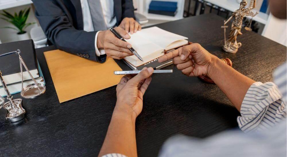 Two people consulting legal documents with an attorney