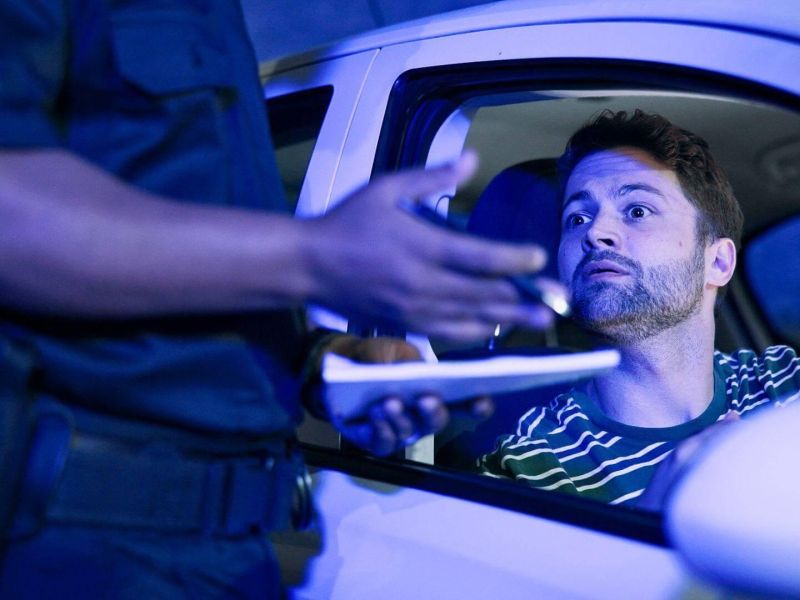 Man in car holding driver's license