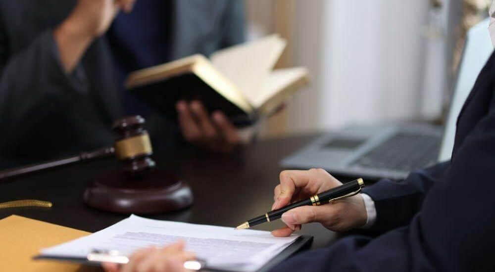 Two people discussing papers with a lawyer for gun rights