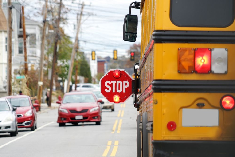 school bus with stop sign flashing on the street