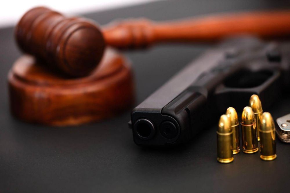 Wooden judge's gavel and gun representing