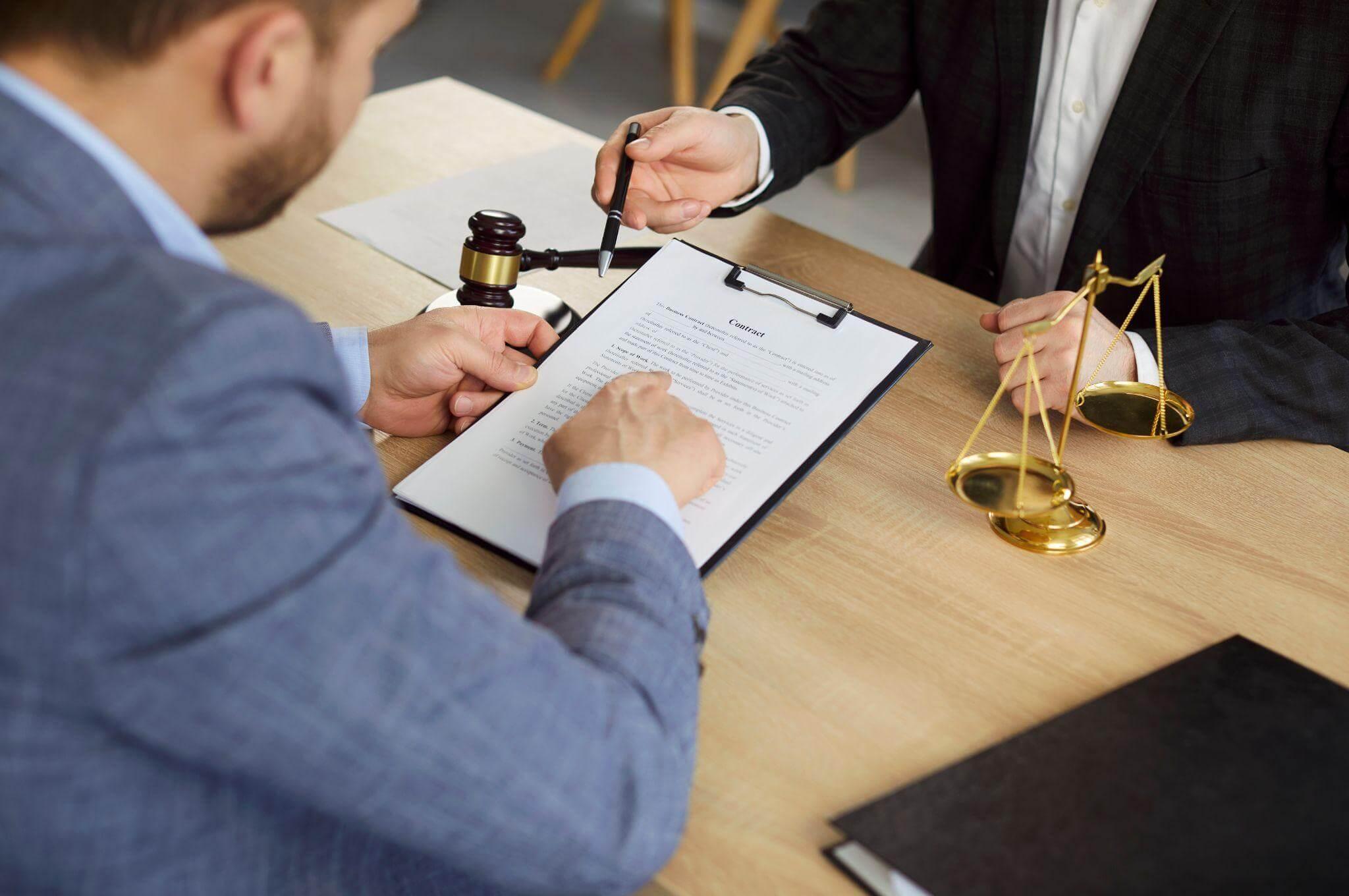 Man with auction gavel and justice scale at table