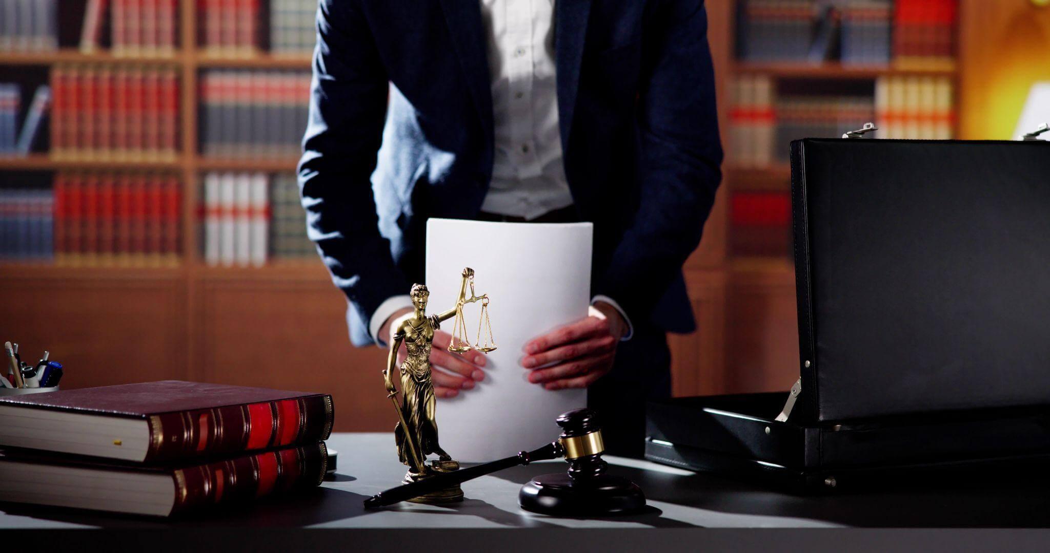 a person holding a piece of paper in front of a desk in a lawyer's office