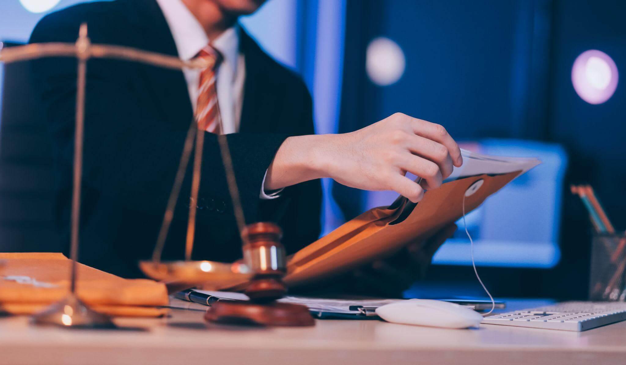 a man in a suit and tie holding a scale of justice