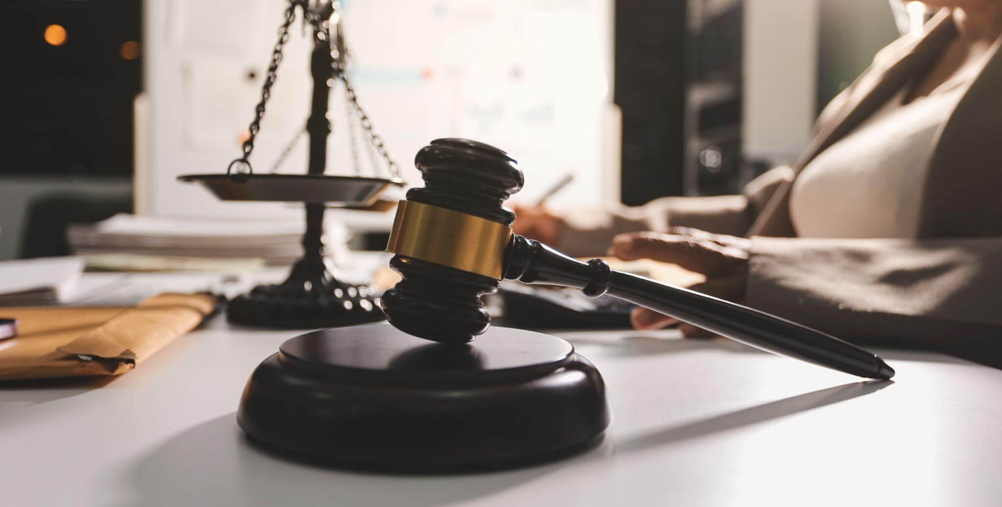 a woman sitting at a desk in front of a judge