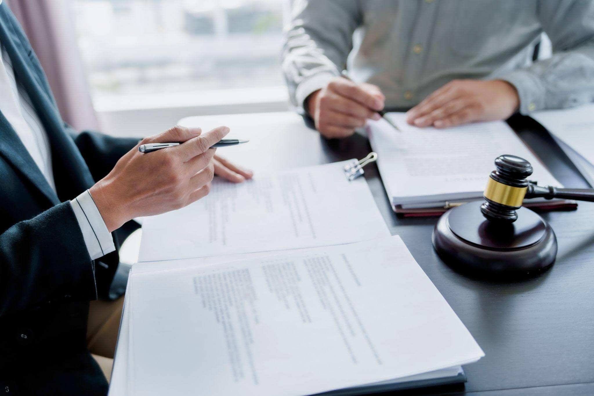 two people sitting at a table with papers and a judge