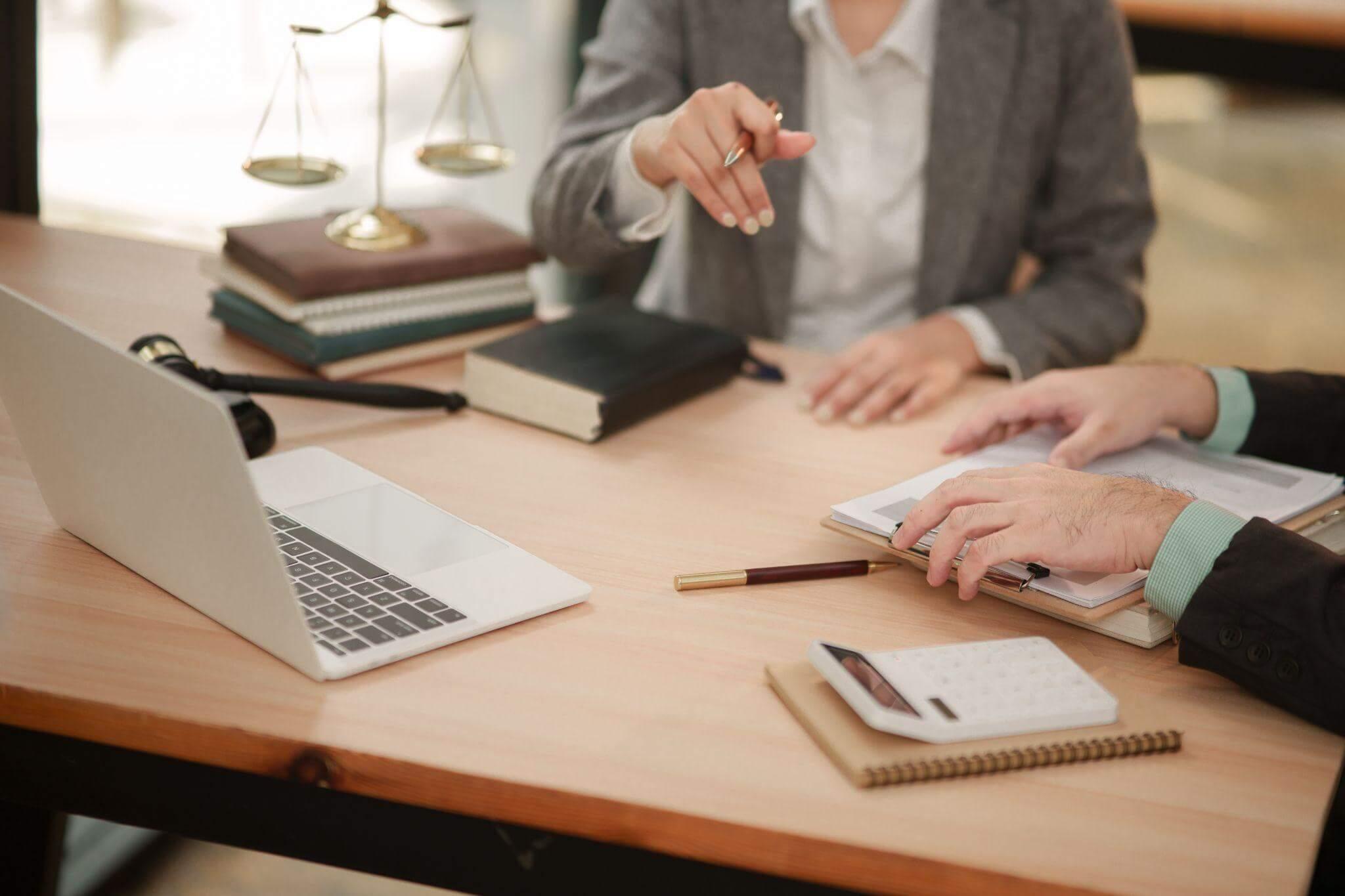 Two people reviewing legal content on a laptop