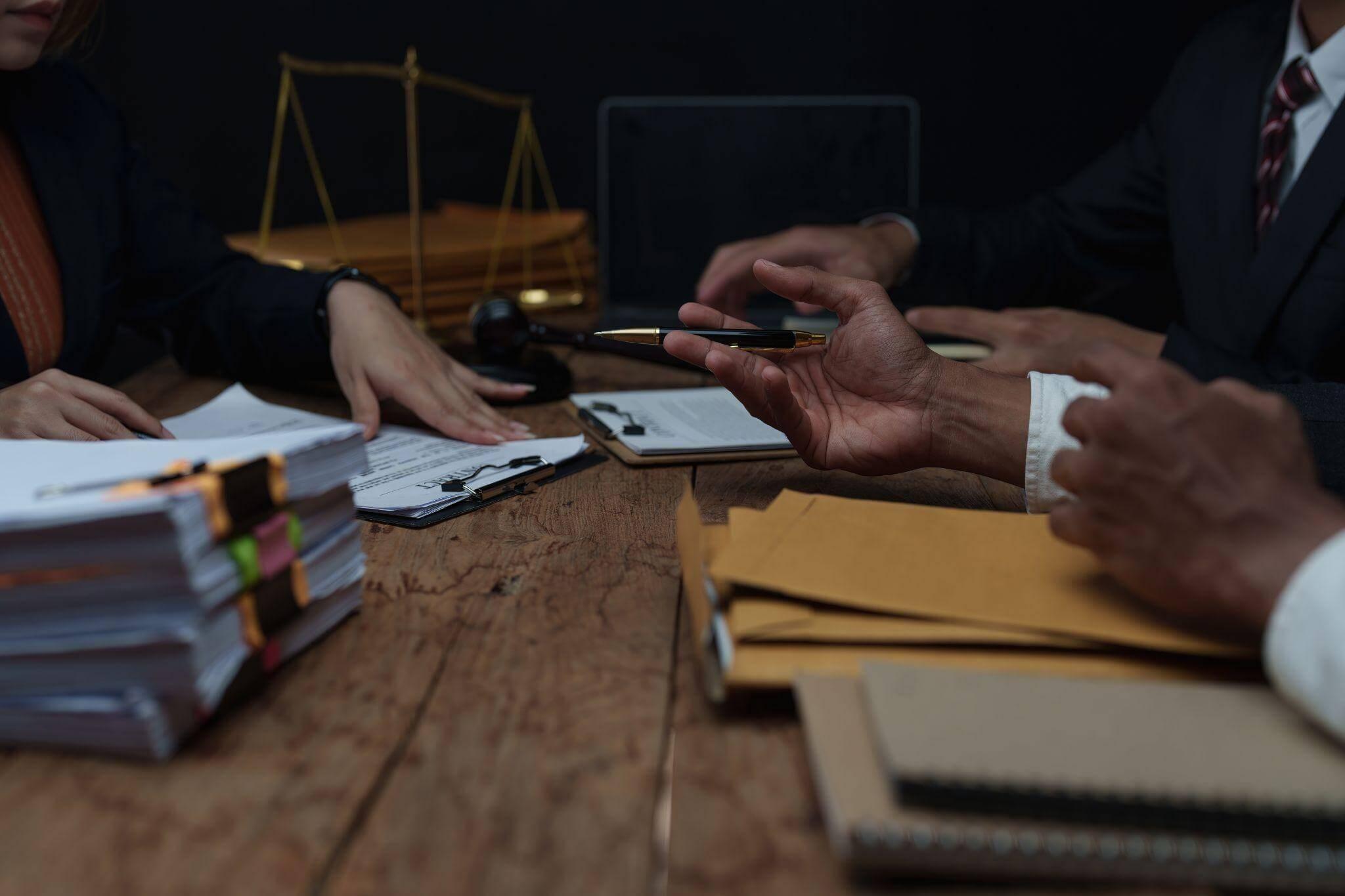 Group of people gathered at a wooden table discussing