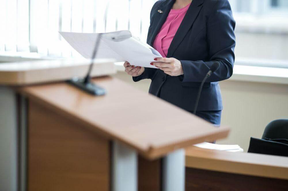 Woman at a podium reviewing content about